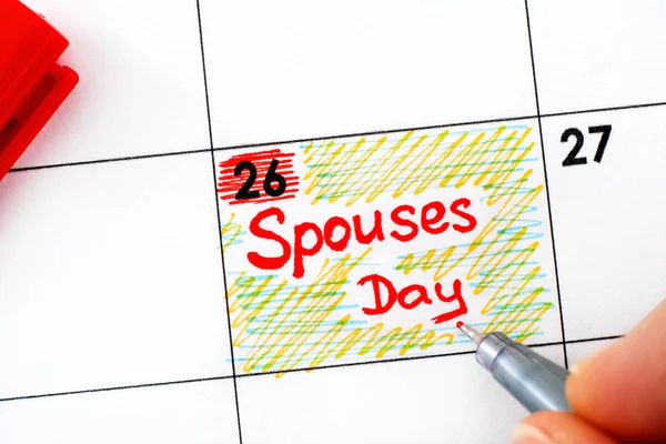 Woman fingers with pen writing reminder Spouses Day in calendar. — ストック写真