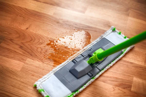 Mop cleaning spilled water on parquet. Close up. — ストック写真