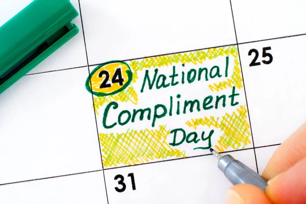 Женские пальцы с ручкой напоминают Национальный день комплиментов — стоковое фото