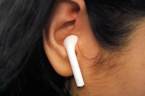 Closeup of wireless earbud in woman ear. — 스톡 사진