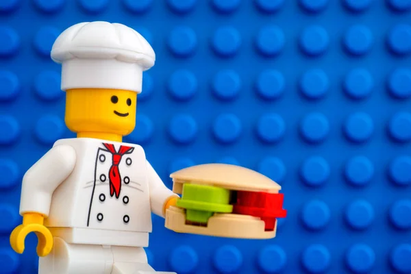 Lego şefi, hamburgerli minyatür figürlü mavi tabaka arka planda. — Stok fotoğraf