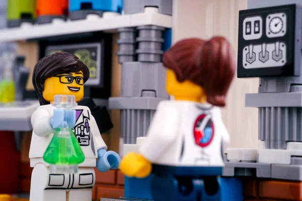 Two Lego scientist minifigures make experiment in laboratory. — Stock Photo, Image