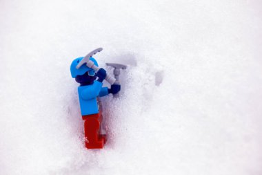 Lego kâşifi karda baltaları olan minicik bir figür.