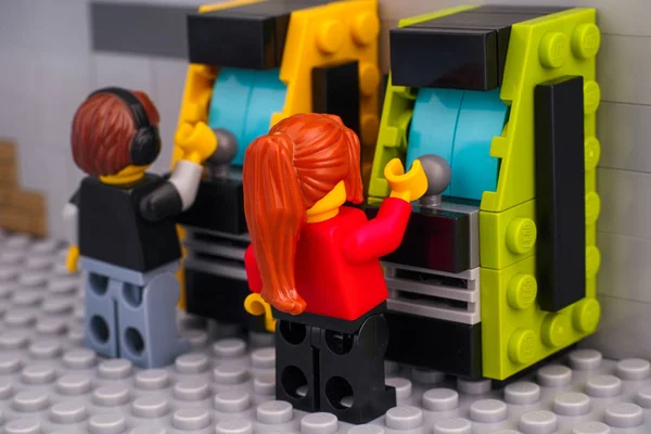 Lego boy and girl playing arcade cabinets. — Stock Photo, Image