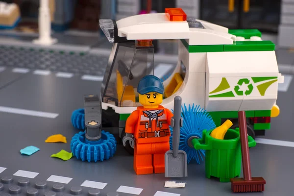 Lego minifigura limpiador con pala cerca del camión barredora en el st — Foto de Stock