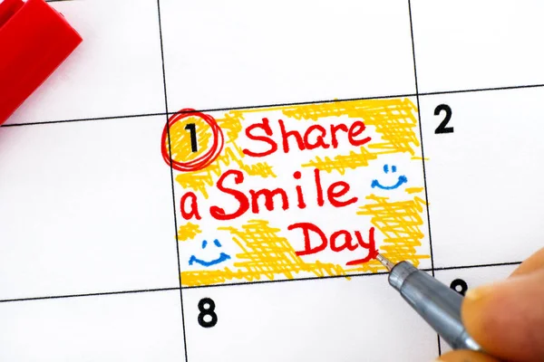 Žena prsty s perem psaní připomínka Share a Smile Day in cal — Stock fotografie