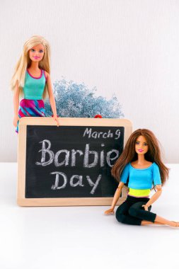 Tambov, Rusya Federasyonu - 24 Şubat 2020 2 Barbie bebek 9 Mart 'ta Barbie Günü sözleriyle tahtaya yakın. Stüdyo çekimi.