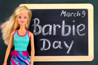 Tambov, Rusya Federasyonu - 24 Şubat 2020 Sarışın Barbie bebek ve 9 Mart Barbie Günü yazılı kara tahta. Stüdyo çekimi.