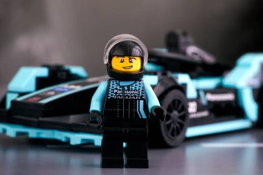 Tambov, Rusya Federasyonu - 19 Şubat 2020 Lego Formula E Panasonic Jaguar Yarış Gen2 sürücüsü minifiki LEGO Speed Champions onun arabasına karşı. Stüdyo çekimi.