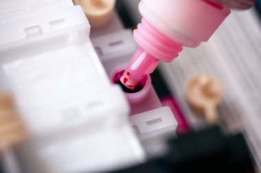 Mor renkli mürekkeple doldurulmuş bir şişe yazıcı kartuşu. Yakın çekim..