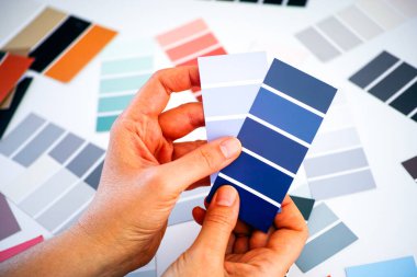 Kadın elleri örnek paletlerde mavi rengi seçiyor. Yakın plan..