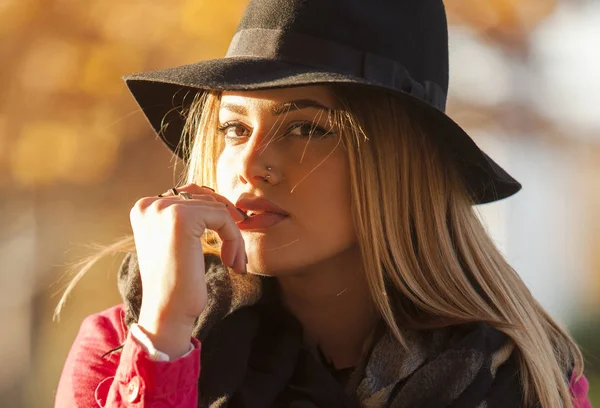 Sensuell blond ung kvinna med hatt och finger på hennes läppar — Stockfoto