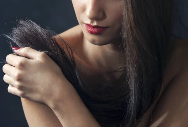 Junge Frau, nackte Schultern, spielt mit ihren schwarzen Haaren, sinnlich — Stockfoto