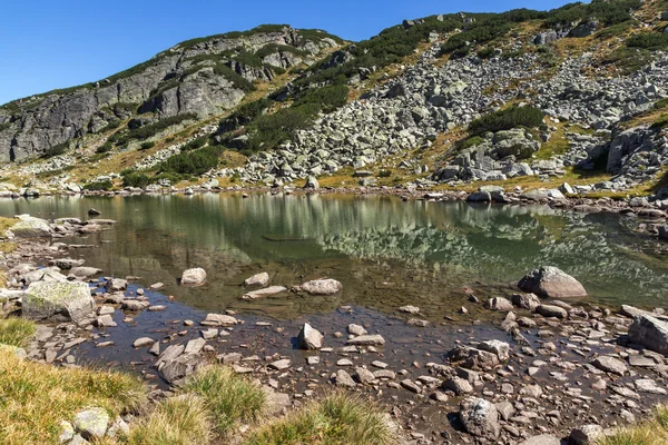 Stenar i vattnet i liten sjö, Rilabergen — Stockfoto