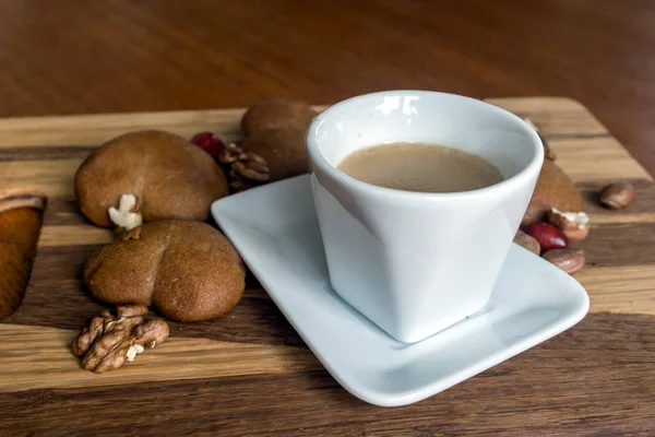 Чашка кофе с подкладкой пряников и орехами грецкий орех и фундук — стоковое фото