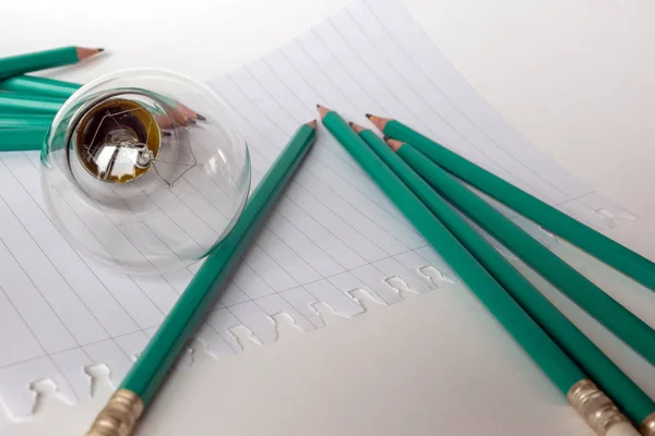 Composição com Lâmpada com notebook e lápis — Fotografia de Stock