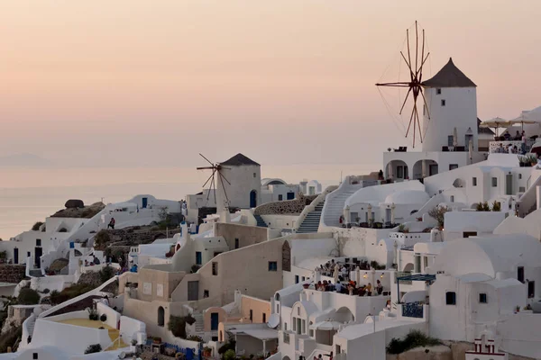 Traumhafter sonnenuntergang über weißen windmühlen in der stadt oia und panorama zur insel santorini — Stockfoto