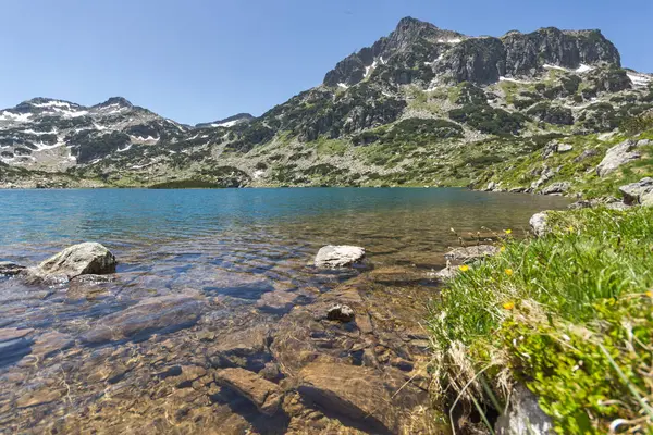 Úžasný výhled na vrchol Dzhangal, Popovo jezero a žluté květy vpředu, pohoří Pirin — Stock fotografie