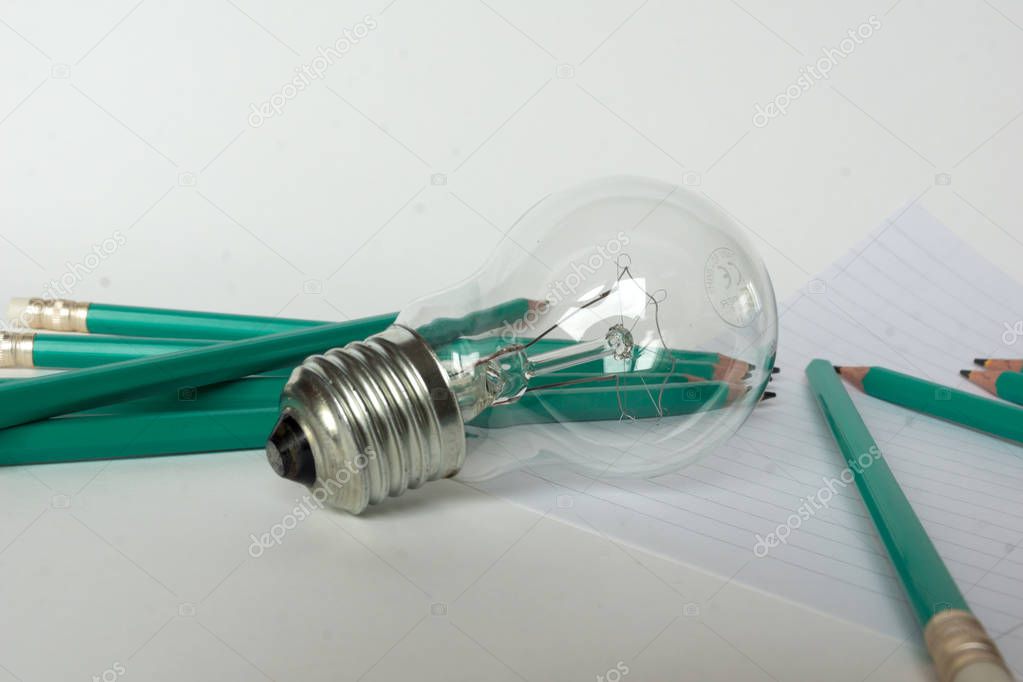 Business Composition with Light bulb with notebook and pencils
