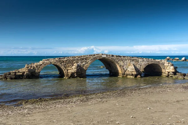 Krajina s středověký most ve vodě na pláži Argassi beach, ostrov Zakynthos — Stock fotografie