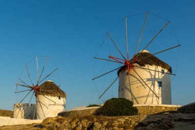 Mikonos Adası üzerinde şaşırtıcı günbatımı ve beyaz yel değirmenleri