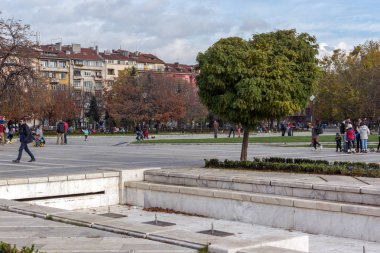 Sofia, Bulgaristan-12 Kasım 2017: Sofya Ulusal Kültür Sarayı önünde park insanlar yürürken