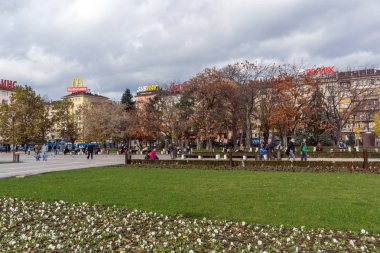 Sofia, Bulgaristan-12 Kasım 2017: Sofya Ulusal Kültür Sarayı önünde park insanlar yürürken