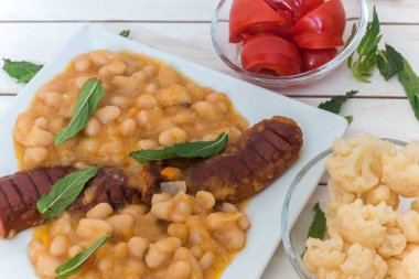 Sosis ve Marine biber ve karnabahar beyaz Akdeniz ahşap arka plan üzerinde turşu ile fasulye