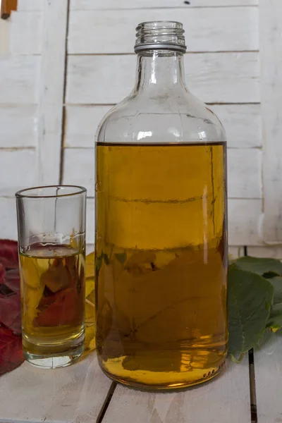 Bouteille et verres de brandy sur fond de feuilles d'automne — Photo