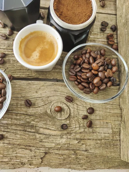 Cup and grain of coffee over wooden background