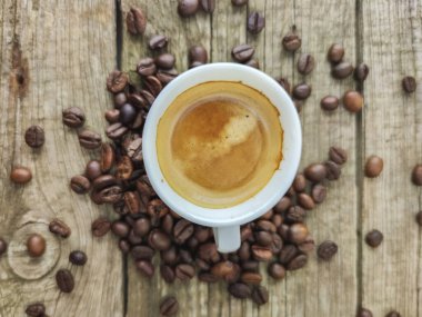 Ahşap zemin üzerinde fincan ve kahve taneleri