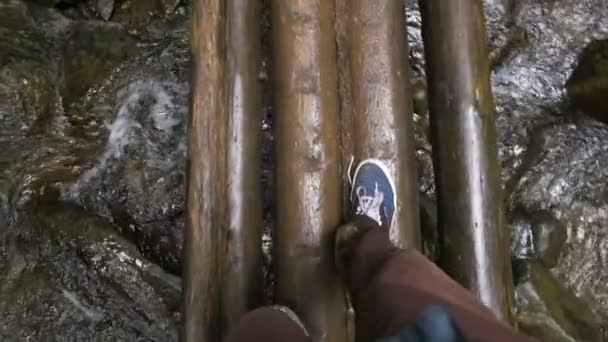 Людина на мосту над гірською річкою — стокове відео