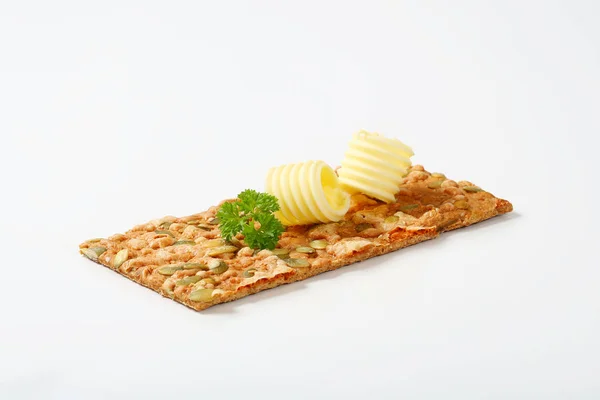 Pumpkin seed cracker with butter — Stock Photo, Image