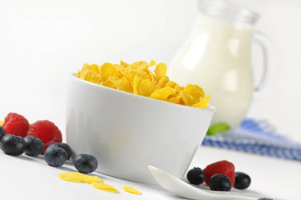 Tazón de hojuelas de maíz y jarra de leche —  Fotos de Stock