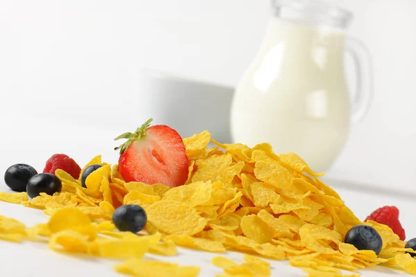 Glaskanna, og mjölk och cornflakes med frukter — Stockfoto