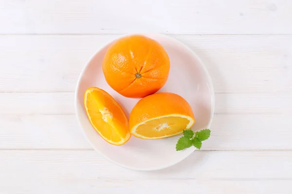 Целые и нарезанные апельсины — стоковое фото