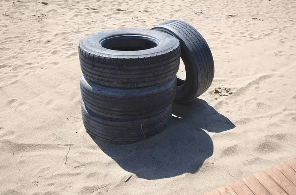 Cztery opony opuszczony na plaży — Zdjęcie stockowe