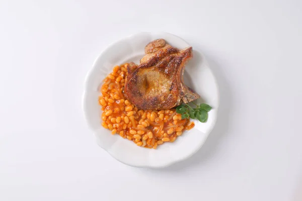 Pork chop and baked beans — Stock Photo, Image
