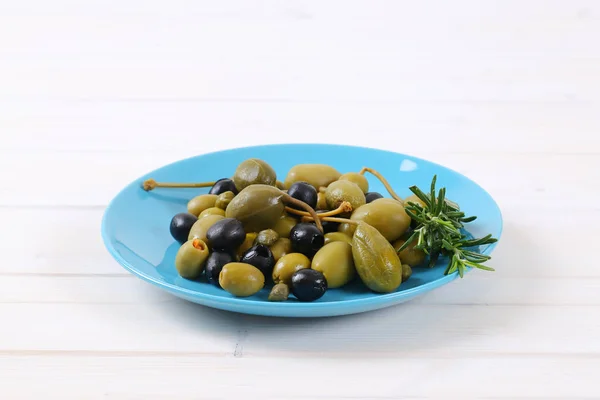Groene en zwarte olijven met kappertjes en caper bessen — Stockfoto