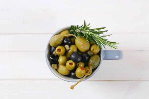 Green and black olives with capers and caper berries — Stock Photo, Image