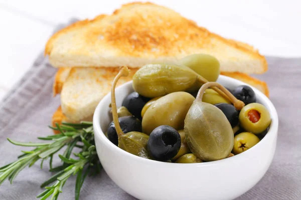 pickled olives, capers and caper berries with toast