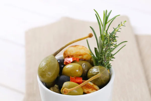 Olive in salamoia, capperi, bacche di cappero e aglio — Foto Stock