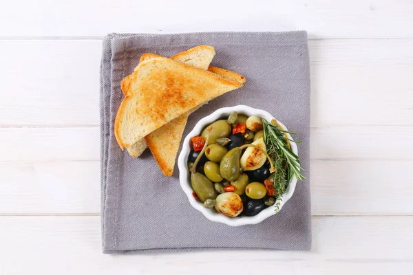 Ingemaakte olijven, kappertjes en caper bessen met toast — Stockfoto