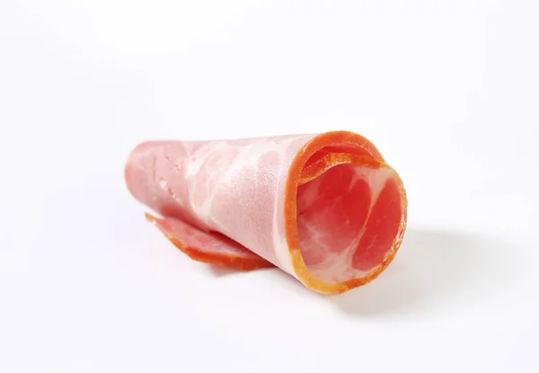 Scheiben geräuchertes Schweinefleisch - zusammengerollt — Stockfoto