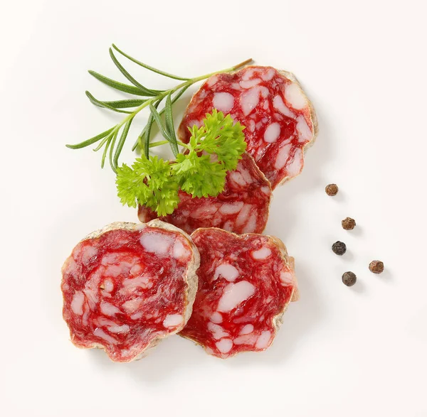 Slices of French dry cured salami with spices — Stock Photo, Image