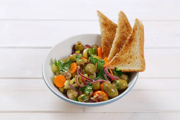 Ensalada de verduras con aceitunas en escabeche y tostadas — Foto de Stock