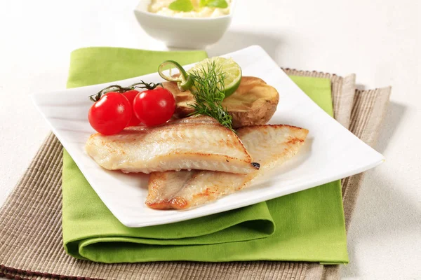 Filets de poisson sans peau avec demi-pomme de terre cuite au four — Photo