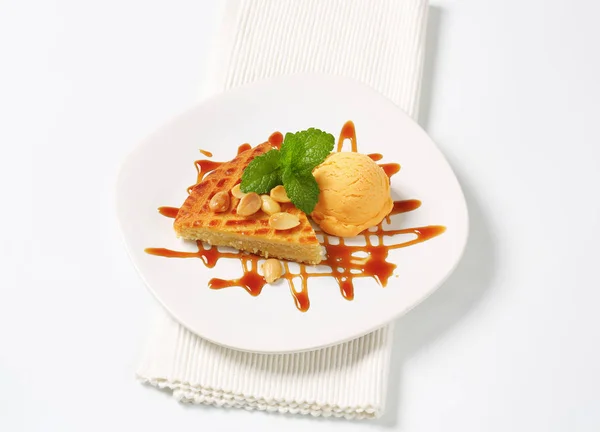 Almond cake with ice cream and caramel sauce — Stock Photo, Image