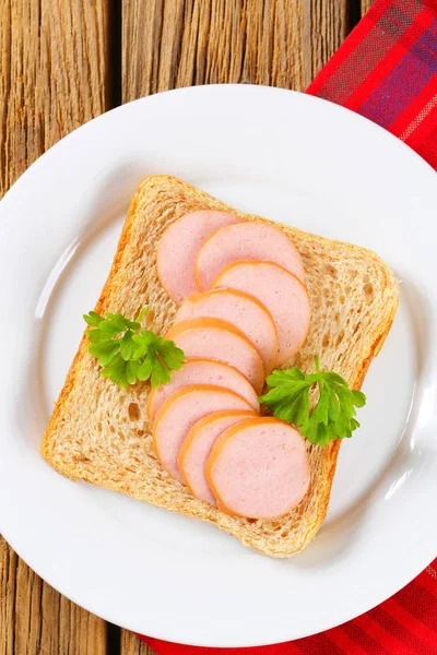 Whole wheat bread with sliced sausage — Stock Photo, Image