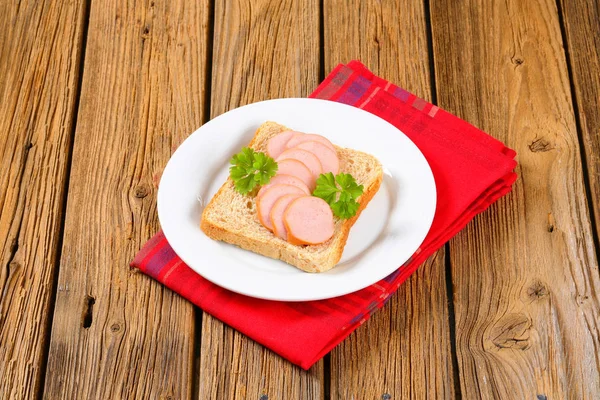 Teljes kiőrlésű kenyér, a szeletelt kolbászt — Stock Fotó